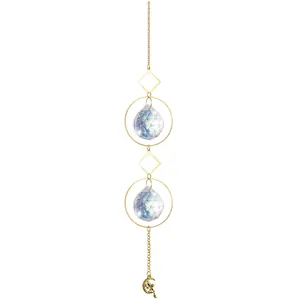 Close-up detail of faceted crystal suncatcher featuring a golden fairy and moon pendant