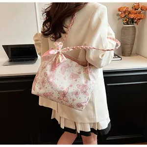 Detailweergave van een grote draagtas met roze vlinderprints en gevlochten handvatten