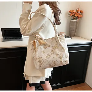 Elegante shopper met vlinderprint en strikdetail, gedragen door model op kantoor