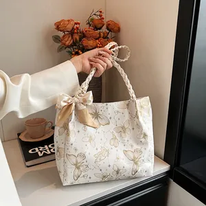 Elegante draagtas met vlinderprint, gevlochten handvatten en decoratieve strik