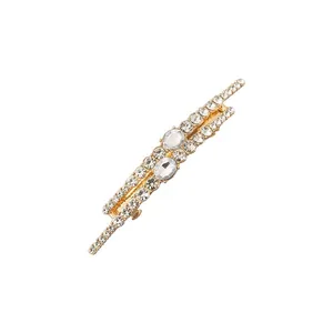 Close-up detail of a luxury gold hair clip encrusted with shimmering rhinestones.