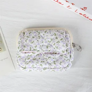 Detailed view of a white floral quilted mini coin purse with snap button pocket