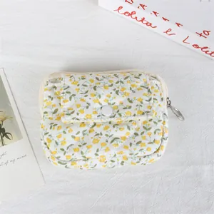 Overhead detail view of a quilted floral mini pouch with flap button and zipper closure