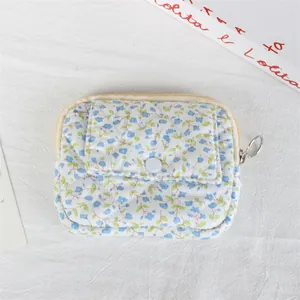 Detailed macro view of a floral quilted mini pouch with a snap flap and zipper closure