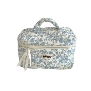 Elegante borsa per cosmetici trapuntata a fiori blu con manico e dettaglio in nastro