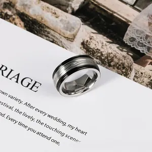 Detailed close-up of a silver and black stainless steel men's ring with textured band