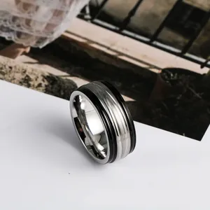 Detail view of a men's minimalist stainless steel ring with black enamel drip edges