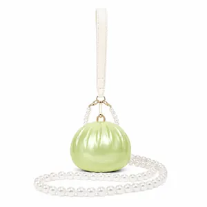Detail of lime green acrylic shell evening bag with elegant pearl handle and crossbody strap