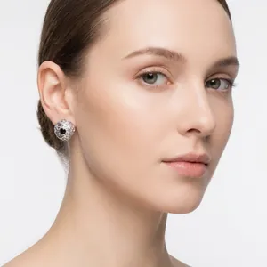 High-quality close-up of vintage patterned stainless steel round stud earrings worn by a model