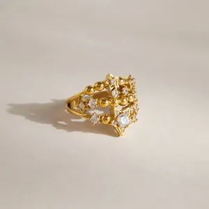 Primo piano di anello in acciaio inossidabile dorato con stelle in zircone e perline