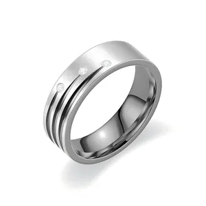 Gros plan d'une bague en acier inoxydable brossé avec trois diamants étincelants sertis.