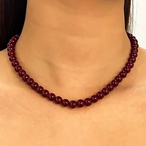 Nahaufnahme eines eleganten burgunderfarbenen Perlen-Halsbandes an einem Model