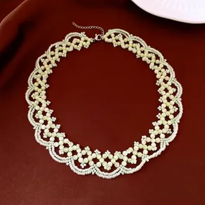 Collier de perles fait main avec motifs floraux en œil de chat sur tissu marron