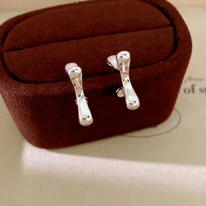 Detailed view of elegant silver geometric line stud earrings on brown velvet box