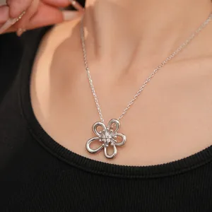 Primo piano di un'elegante collana con ciondolo a fiore d'argento con zirconi.