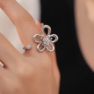 Dettaglio dell'anello aperto a fiore argentato con pietre di zirconia cubica scintillanti.