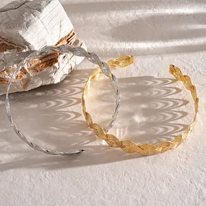 Close-up of wavy twisted texture metal choker necklaces in silver and gold tones