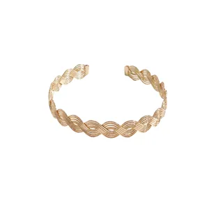 Elegant golden wave twisted multi-strand metal cuff bracelet in minimalist vintage style.