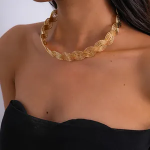 Macro detail of a vintage gold wave braided geometric choker necklace worn on a model.