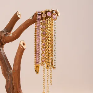 Elegante set di bracciali in acciaio placcato oro 18K con cristalli rosa su supporto di legno