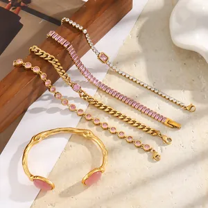 Dettaglio di bracciali in acciaio inossidabile placcato oro 18K con pietre rosa su legno