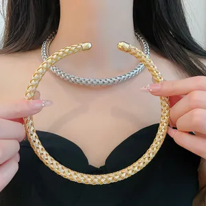 Nahaufnahme von gold- und silberfarbenen gewebten Metall-Halsketten im Minimal-Design.