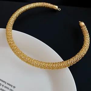 Detailansicht eines goldenen geflochtenen Metall-Chokers auf einem Porzellanteller