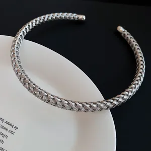Detailaufnahme eines minimalistischen silbernen geflochtenen Metall-Chokers auf Teller