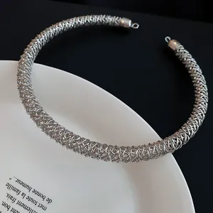 Nahaufnahme einer einzigartigen silbernen Choker-Halskette aus Metallgeflecht auf einem Teller