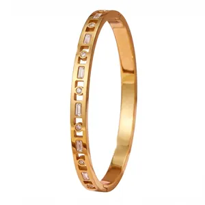 Close-up of gold stainless steel bangle inset with rectangular and round zirconia