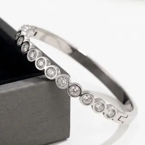 Detailed view of silver stainless steel bangle with round bezel-set cubic zirconia
