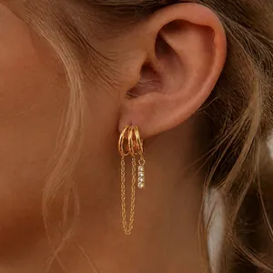 Elegant gold stainless steel tassel earrings with cubic zirconia shown on model