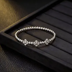 Vista dettagliata di un bracciale a sfere in acciaio inox argento con fiori di diamanti.