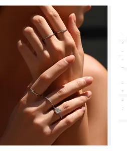 Close-up van stapelbare moissanite sterling zilveren ringen op een hand, luxe sieraden detail