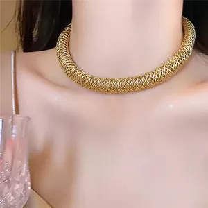 Dettaglio della collana girocollo in maglia dorata intrecciata, stile elegante e chic.