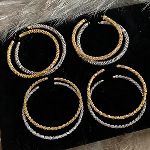 Primo piano di collane girocollo metalliche intrecciate in oro e argento