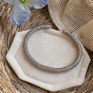 Dettaglio ravvicinato della collana girocollo intrecciata con trama a rete complessa