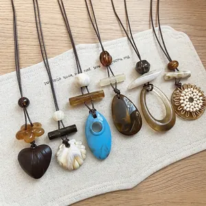 Collection of vintage resin geometric pendant necklaces on a rustic canvas background