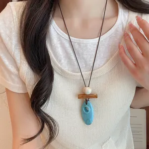 Close-up of geometric resin pendant necklace on a long cord for layered styling