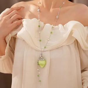 Elegante Perlenkette mit grünem Erdbeer-Anhänger als modisches Accessoire für Damen