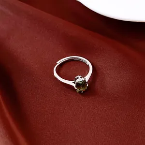 Nahaufnahme eines eleganten ovalen grünen Zirkonia-Rings auf rotem Satinhintergrund.