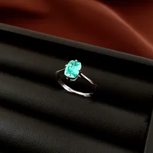 Nahaufnahme eines silbernen Rings mit einem ovalen grünen Zirkonia in einem schwarzen Etui.