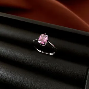 Makroaufnahme eines minimalistischen Silberrings mit einem ovalen rosa Zirkonia-Stein.