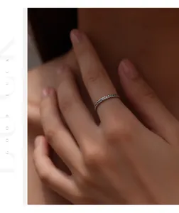 Detail view of a vintage braided S925 sterling silver wheat stalk ring worn on a finger
