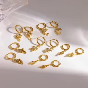 Detailansicht der goldenen Creolen aus Edelstahl mit Meeresmotiven und Kristallen