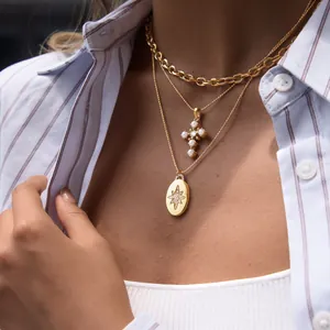 Detailaufnahme der mehrlagigen goldenen Halskette aus Edelstahl mit Stern- und Kreuzanhänger