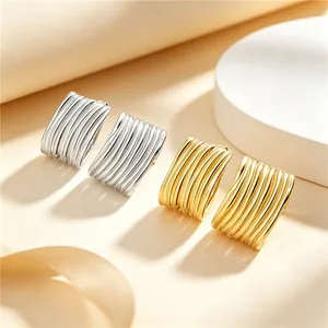 Vue détaillée de boucles d'oreilles en acier inoxydable avec design texturé à rayures