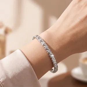 Primo piano di un bracciale scintillante in acciaio inossidabile con zirconi sul polso.