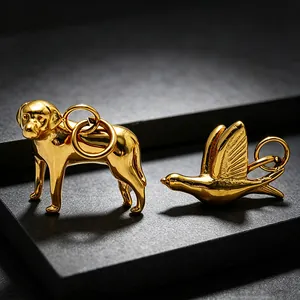 Close-up of 18k gold plated stainless steel dog and bird charms for DIY jewelry.