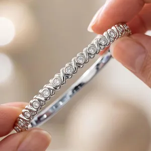 Close-up of an elegant stainless steel bangle with circular diamond-set settings for women